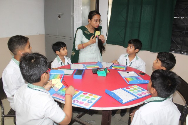 Teacher guiding students with colourful activity kits